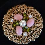 Spilla denominata Fashion Splendor firmata Sarah Coventry del 1960 circa, molto grande, metallo color oro con perle, cabochons di pasta vitrea rosa e cristalli peridot - VINTAGE AMOREMIO