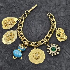 Bracciale charms americani anni ‘60, grande catena di metallo dorato con ciondoli di vari soggetti, con cristalli, perle e paste vitree - VINTAGE AMOREMIO